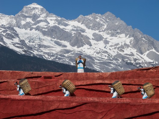 Lijiang, Yunnan, China: Nakhi people carrying the typical baskets of the region; scene from a public perfomance in Jade Dragon Snow Mountain Open Air Theatre  Photo by CEphoto, Uwe Aranas / CC-BY-SA-3.0
